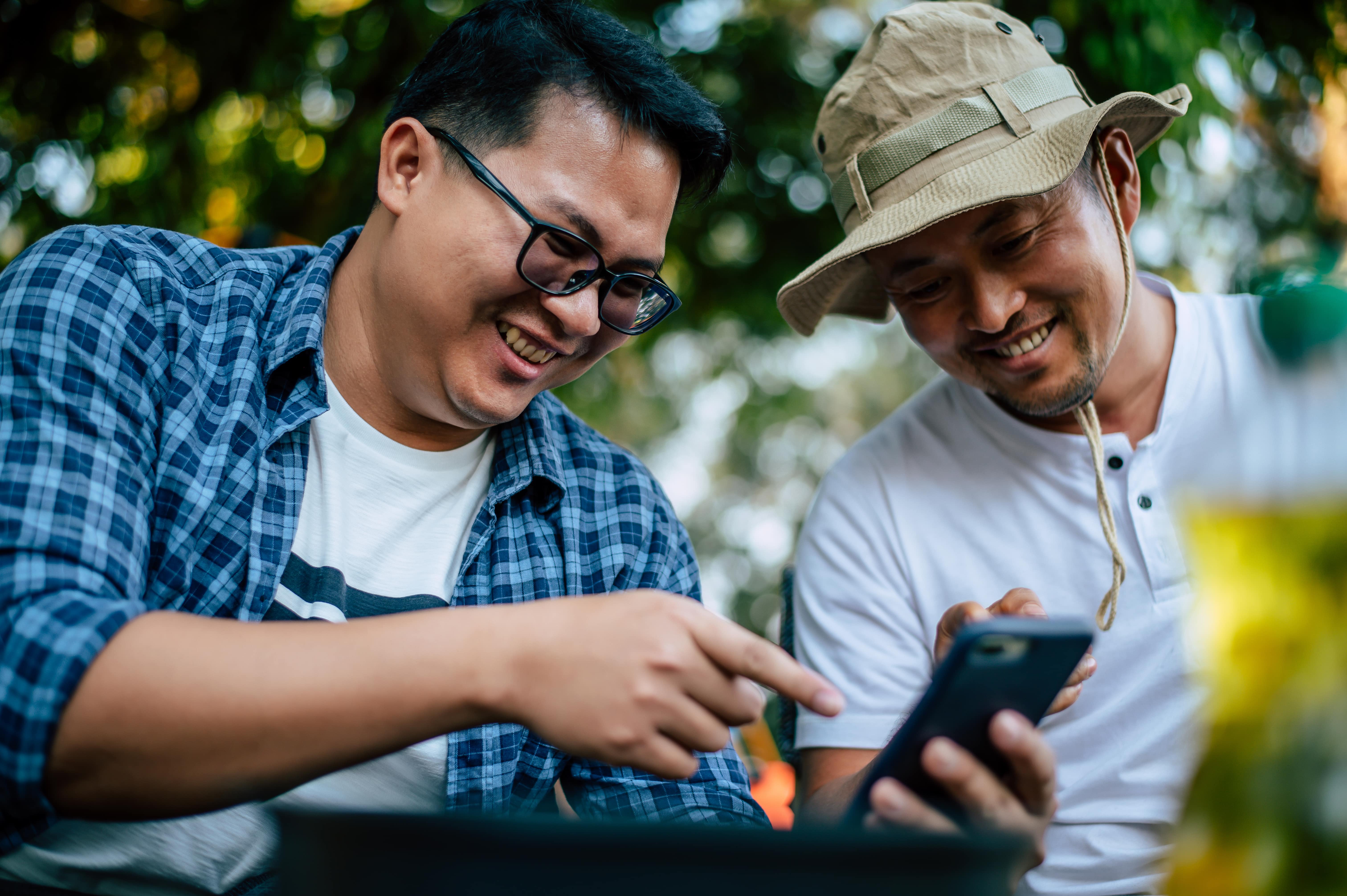 portrait-happy-asian-man-friends-sitting-chair-camp-with-talking-looking-smartphone-cooking-set-front-ground-outdoor-cooking-traveling-camping-lifestyle-concept-min.jpg